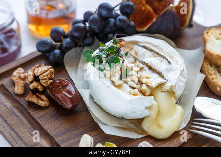 Baked camembert cheese with figs, honey, grapes and nuts. Top view Stock Photo