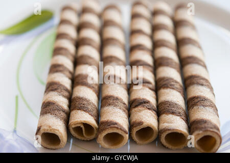 rolled wafers at the chocolate on a white dish Stock Photo