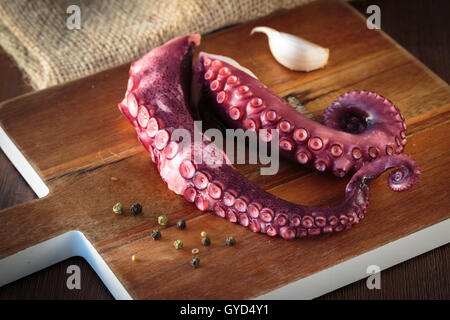 Delicious cooked octopus tentacles on a chopping board Stock Photo