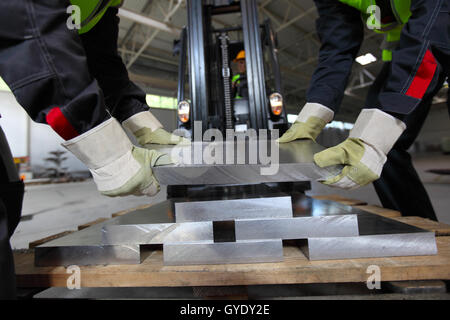 Workers taking aluminium billet at CNC machine shop Stock Photo