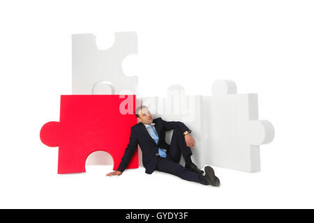 Business man thinking about problem solution near big puzzle Stock Photo