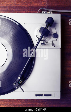 Turntable playing vinyl record with music. Home hi-fi system for audio enthusiast. Top view. Stock Photo