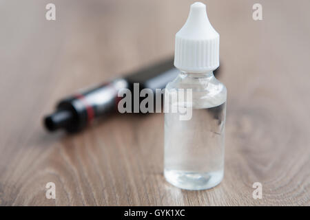 metal vape pen Transparent bottle of e-cig glycerin nicotine flavored liquid for vaping.  Refill for electronic vaporizer smoking device Stock Photo