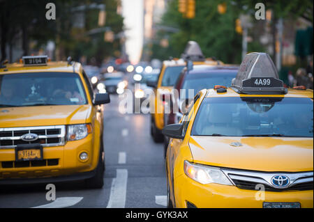 NEW YORK CITY - SEPTEMBER 4, 2016: Yellow taxis head downtown on a typical late afternoon scene on lower Fifth Avenue. Stock Photo