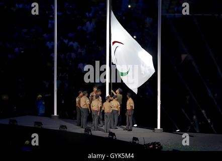 The Paralympic flag is lowered by soldiers during the closing ceremony on the eleventh day of the 2016 Rio Paralympic Games at the Maracana, Rio de Janeiro, Brazil. Stock Photo