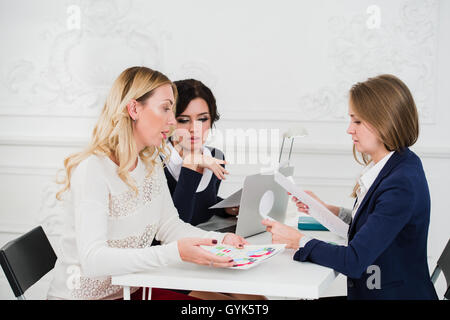 Two Businesswomen Shaking Hands In Modern Office Stock Photo