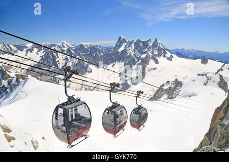 Tourists enjoying the majestic landscape in gondolas from Point Helbronner to Aiguille du Midi, France Stock Photo