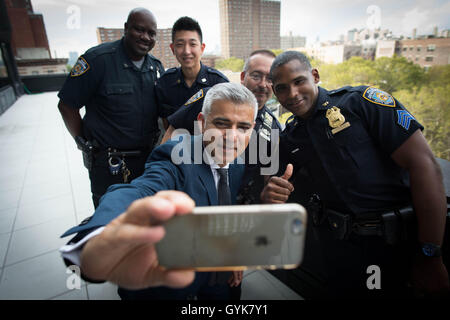 Mayor of London Sadiq Khan takes a 'selfie' with police officers in Harlem before taking the subway to the 9/11 Memorial in New York where he laid flowers to remember the victims of the 2001 terrorist attack during his six day visit to Canada and the United States. Stock Photo