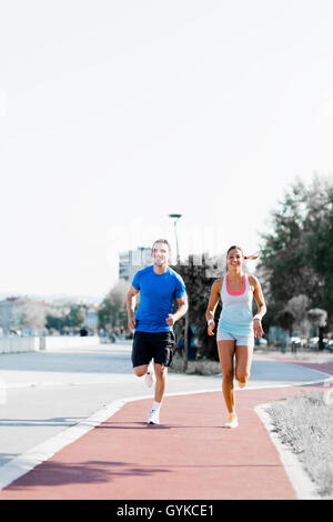 A man and a woman jogging on a city track Stock Photo
