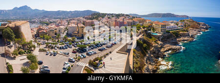 View to beautiful Corsica coastline and historic houses in Calvi old town with turquoise clear ocean water, Corsica, France, Eur Stock Photo