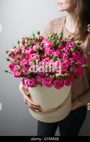Luxury bouquets of flowers in the hat box. roses in the hands women. Pink Colour peonies