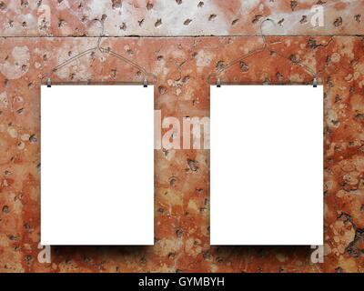 Close-up of two blank frames hanged by clothes hangers against orange old weathered marble wall background Stock Photo