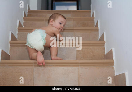 Baby boy crawling up the stairs. Low angle view Stock Photo