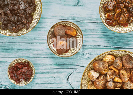 Dried fruits in bowls, retro toning applied, top view. Stock Photo