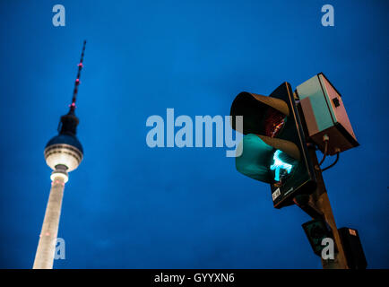 Green walking man figure, Ampelmännchen, at traffic light with television tower Alex at dusk, Alexanderplatz, Berlin, Germany Stock Photo