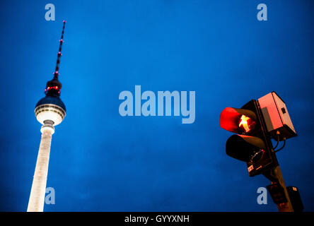 Red walking man figure, Ampelmännchen, at traffic light with television tower Alex at dusk, Alexanderplatz, Berlin, Germany Stock Photo