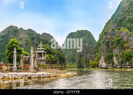Small temple with forested limestone rocks, karst mountains, Ngo Dong River, Song Ngô Dong, Tam Coc, Ninh Binh, Vietnam Stock Photo