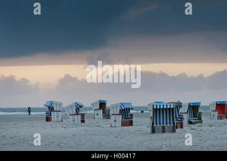 empty roofed wicker beach chairs on the beach in the evening, Germany, Schleswig-Holstein, Northern Frisia, St. Peter-Ording Stock Photo