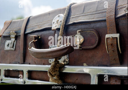 Brown vintage valise on the car roofrack on a sunny summer day against the blue sky Stock Photo