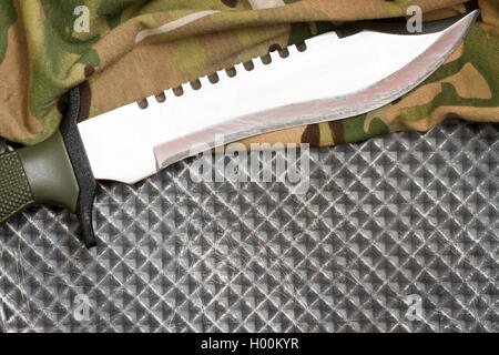 Combat knife and shoes on military camouflage fabric background closeup Stock Photo