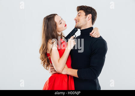 Happy young couple embracing and posing with gun Stock Photo