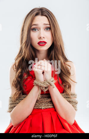 Portrait of scared young woman bounded with ropes Stock Photo