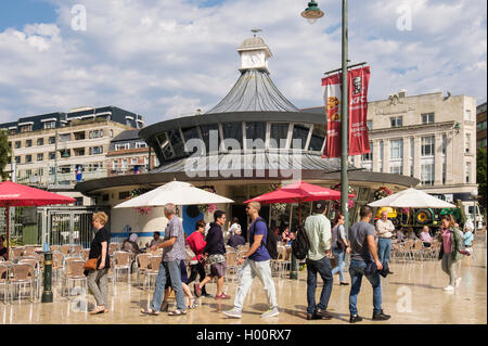 Busy street scene outside with people rushing past The Obscura Cafe in The Square, Bournemouth, Dorset, England, UK, Britain Stock Photo