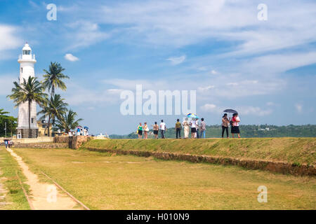 GALLE, SRI LANKA - MARCH 9, 2014: Tourists in front of the oldest Sri Lankan lighthouse placed inside the walls of the ancient G Stock Photo