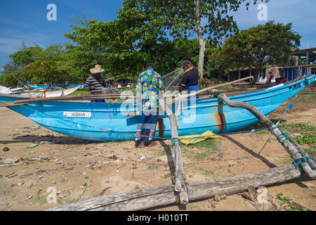 WELIGAMA, SRI LANKA - MARCH 7, 2014: Fishermen preparing fishing net. Tourism and fishing are two main business in this town. Stock Photo