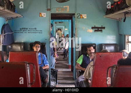 HIKKADUWA, SRI LANKA - MARCH 12, 2014: Commuters sitting in train to Colombo. Trains are very cheap and poorly maintained but it Stock Photo