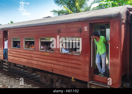 HIKKADUWA, SRI LANKA - MARCH 12, 2014: Local commuters in old train. Trains are very cheap and poorly maintained but it's the be Stock Photo