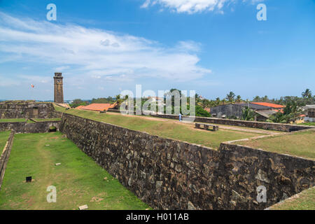 GALLE, SRI LANKA - MARCH 9, 2014: Walls of Galle fort with clock tower in distance.  Fort was originally built in 1684 to house  Stock Photo