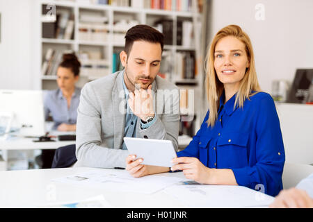 Colleagues discussing ideas on tablet in office Stock Photo