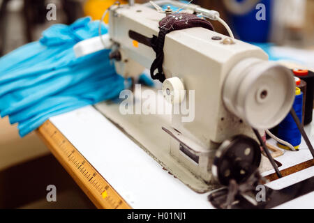 Industrial sewing machine with textile on desk Stock Photo