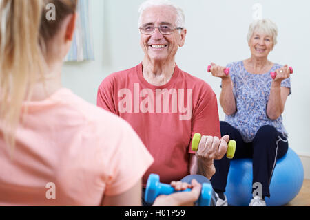 Seniors At Fitness Class With Instructor Stock Photo