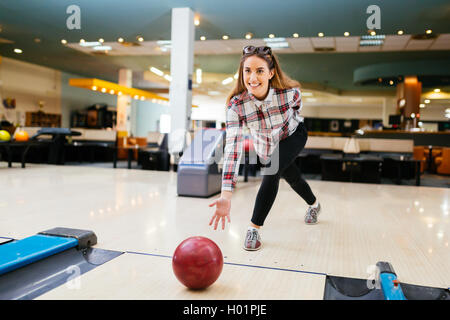 Focused happy woman enjoying bowling at a local club Stock Photo