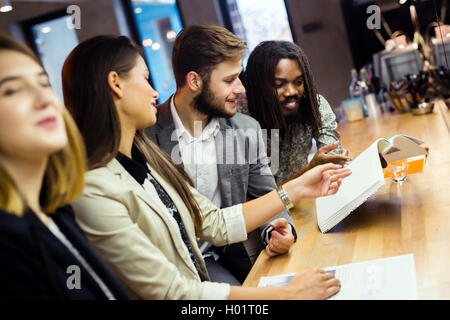 Group of people discussing the contents of the article while sitting in a bar Stock Photo