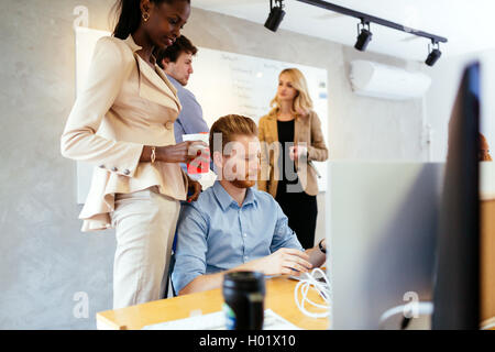 Businesswoman advising colleague in office during work Stock Photo