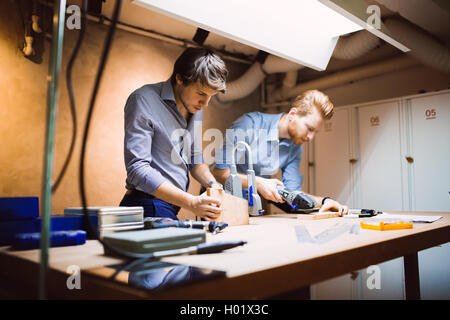 Two designers working together in workshop with precision tools Stock Photo
