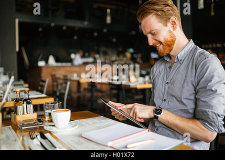 Businessman holding tablet in cafe Stock Photo