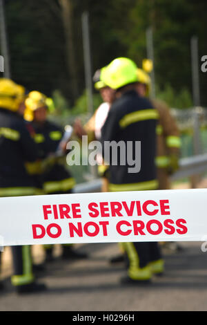 Firefighters at the scene of a major incident. Cordon tape and good depth with selective focus. Upright image. Stock Photo