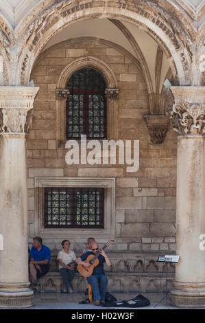 DUBROVNIK, CROATIA - MAY 28, 2014: Man plays guitar in front of Rector's palace. Palace used to serve as seat of the Rector of t Stock Photo