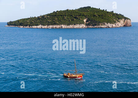 Wooden boat passing by Lokrum island near Dubrovnik, Croatia. Stock Photo