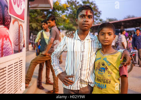 KAMALAPURAM, INDIA - 02 FEBRUARY 2015: Two Indian brothers hugging in street with people around them Stock Photo
