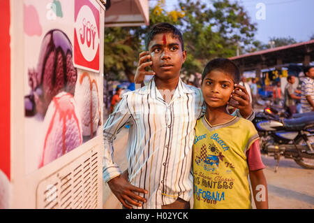 KAMALAPURAM, INDIA - 02 FEBRUARY 2015: Two Indian brothers hugging in street and fooling around, with people around them Stock Photo