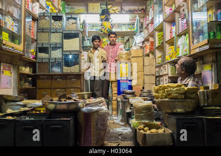 JODHPUR, INDIA - 10 FEBRUARY 2015: Three men in various merchandise store talk business. Stock Photo