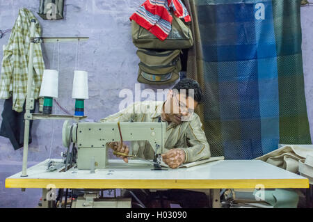 JODHPUR, INDIA - 10 FEBRUARY 2015: Tailor at work in textile factory after working hours. Stock Photo