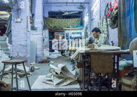 JODHPUR, INDIA - 10 FEBRUARY 2015: Tailor at work in textile factory after working hours. Stock Photo