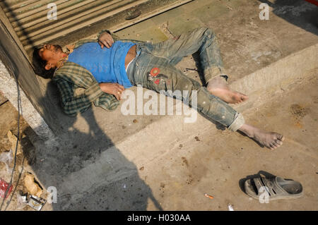 JODHPUR, INDIA - 10 FEBRUARY 2015: Drunk Indian man passed out on street with photographers shadow. Stock Photo