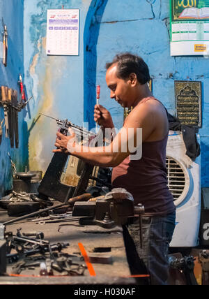 JODHPUR, INDIA - 10 FEBRUARY 2015: Indian man repairs sewing machine. Stock Photo